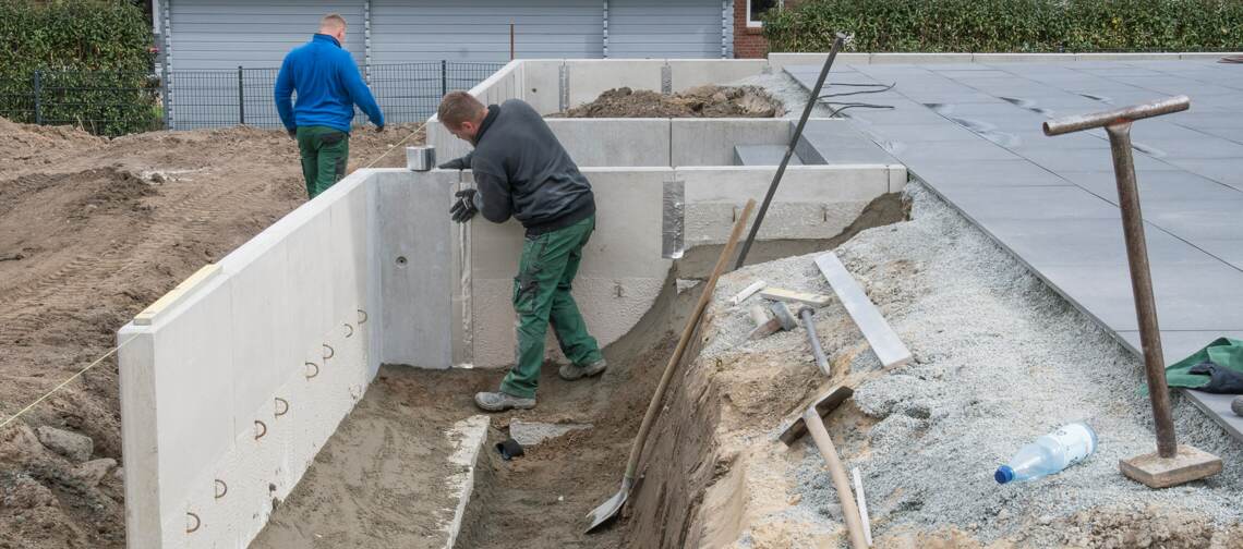Foto: Zwei Arbeiten beim Setzen von Winkelstützen aus Beton